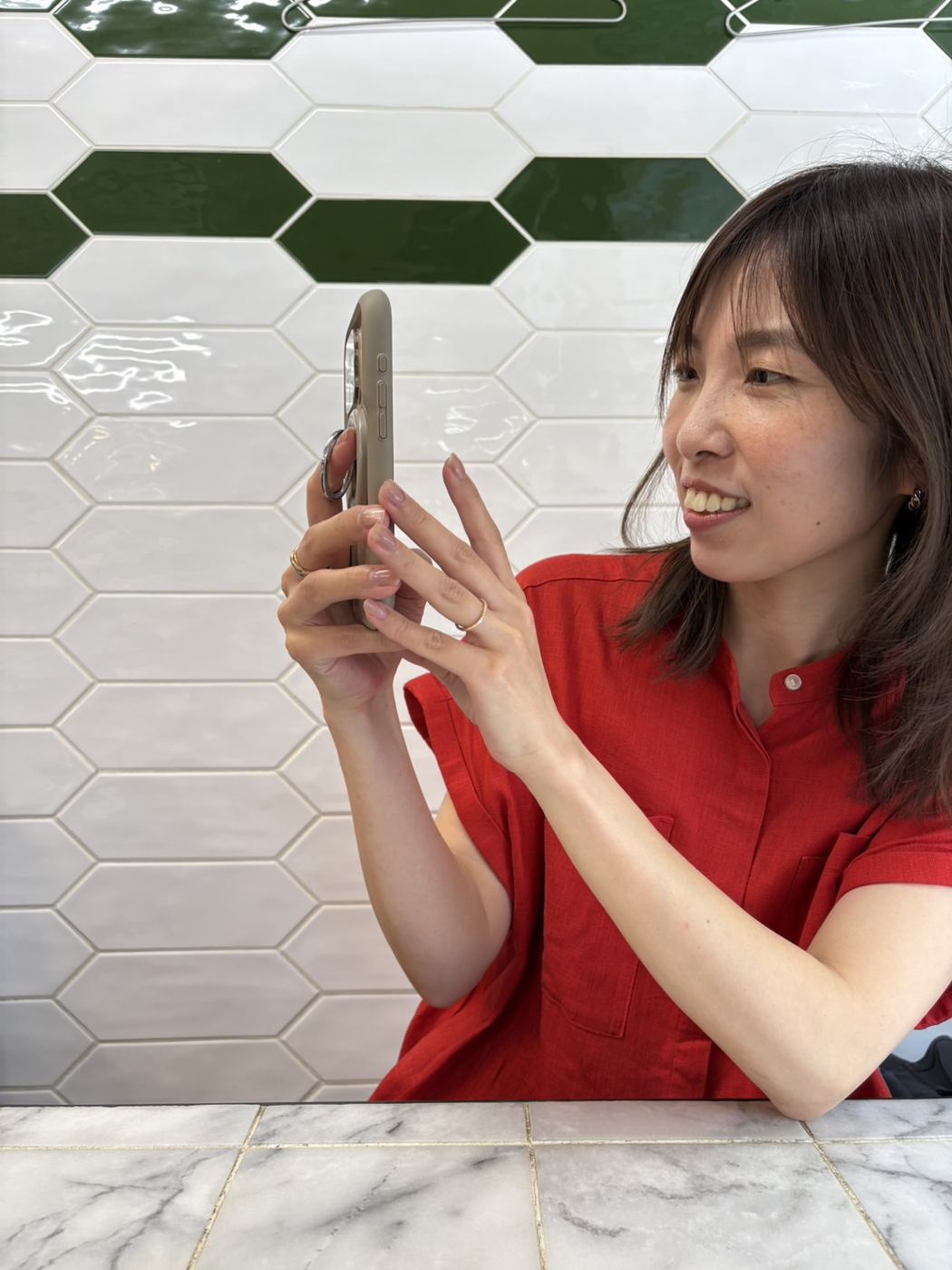 スマートフォンで撮影する岡田茉莉